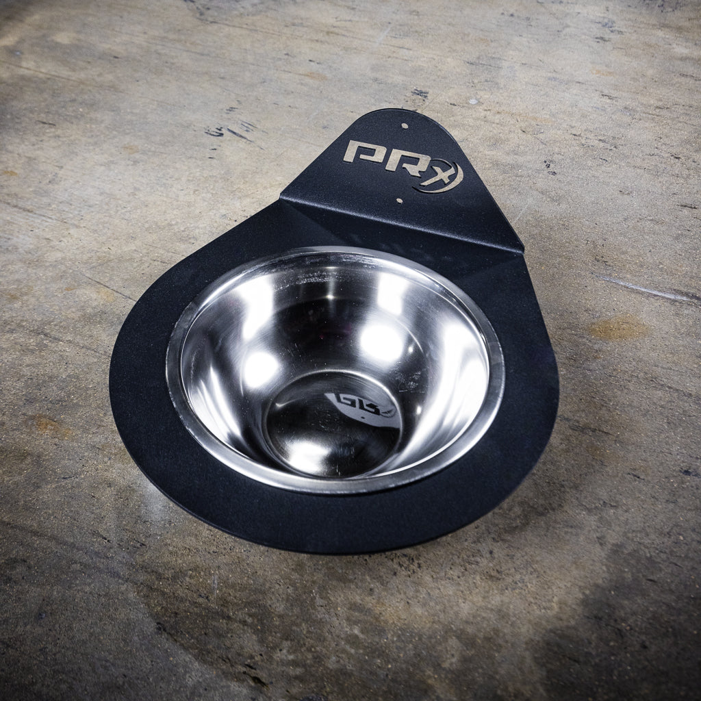 Lifter chalking up at the wall-mounted PRx Chalk Bowl in a home gym