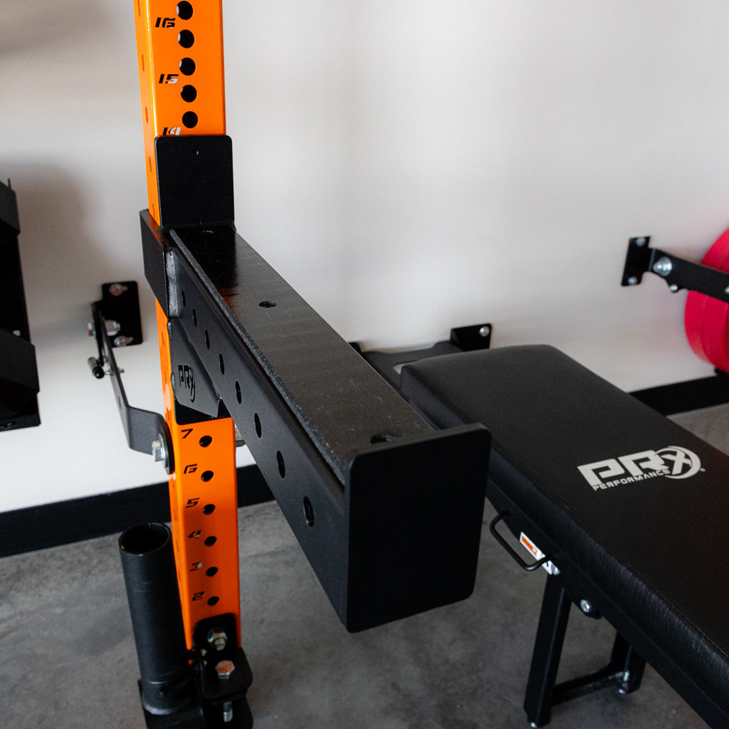 PRx 3x3 Spotter Arms catching a loaded barbell in a home gym