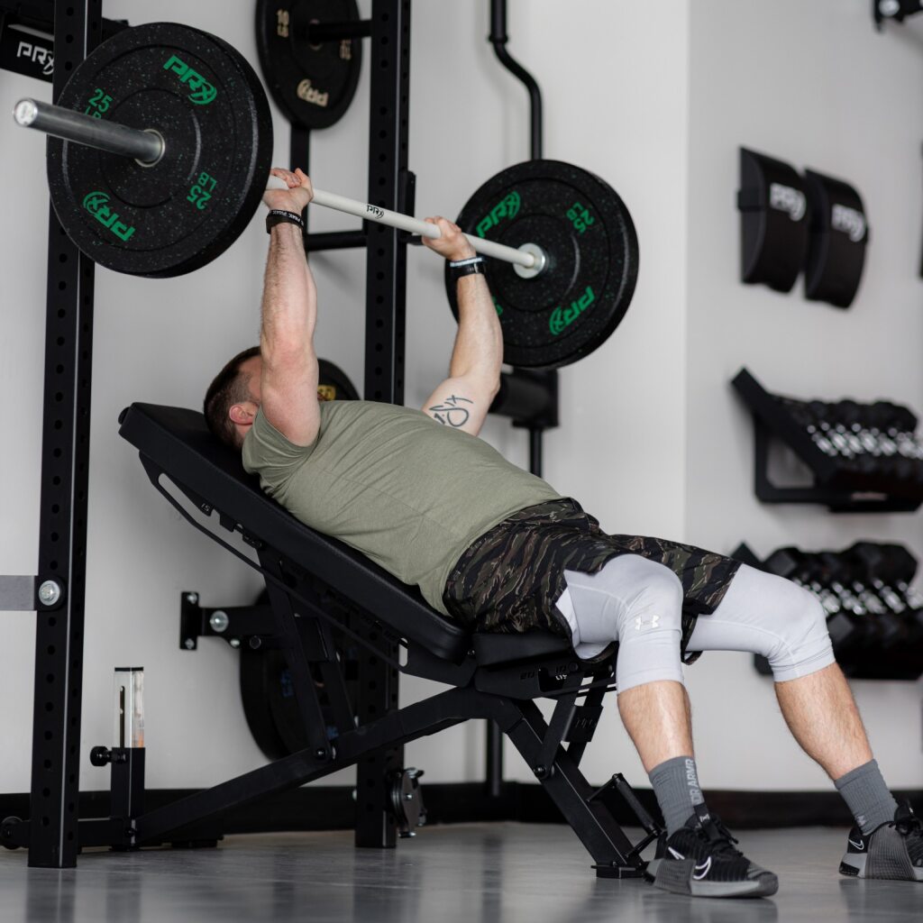 PRx Stealth Weight Bench in a home gym next to a rack