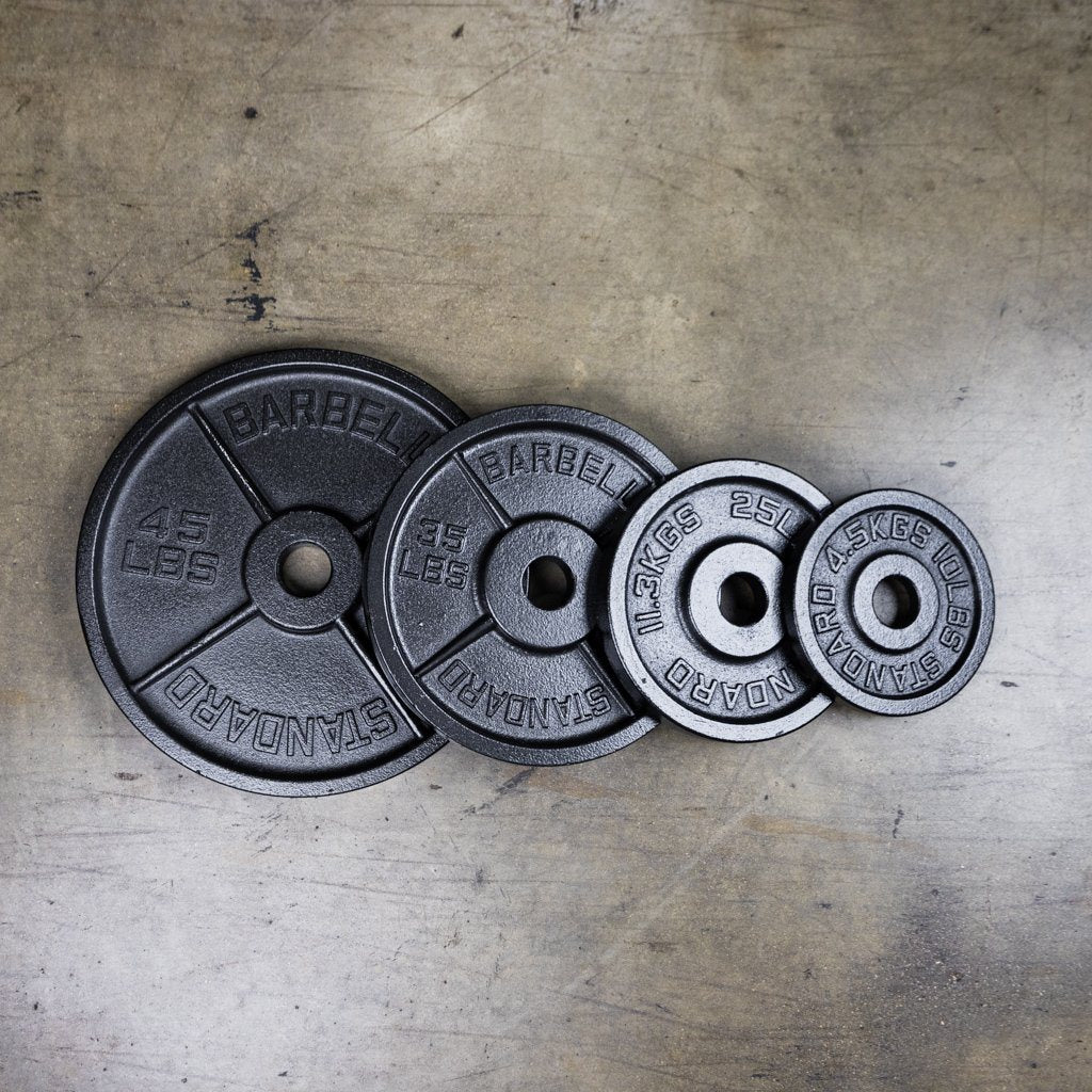 PRx cast iron Olympic plates stacked in a home gym