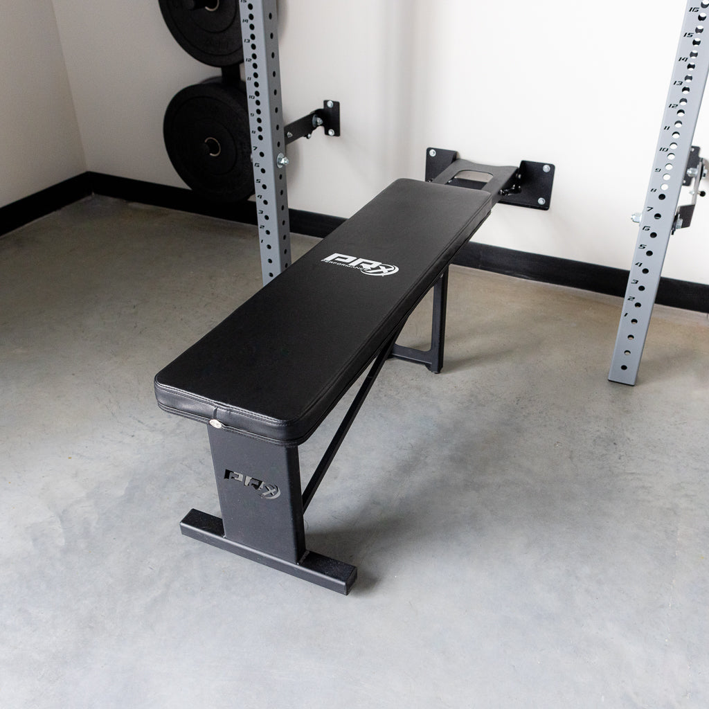 PRx Profile Flat Folding Bench folded against the wall