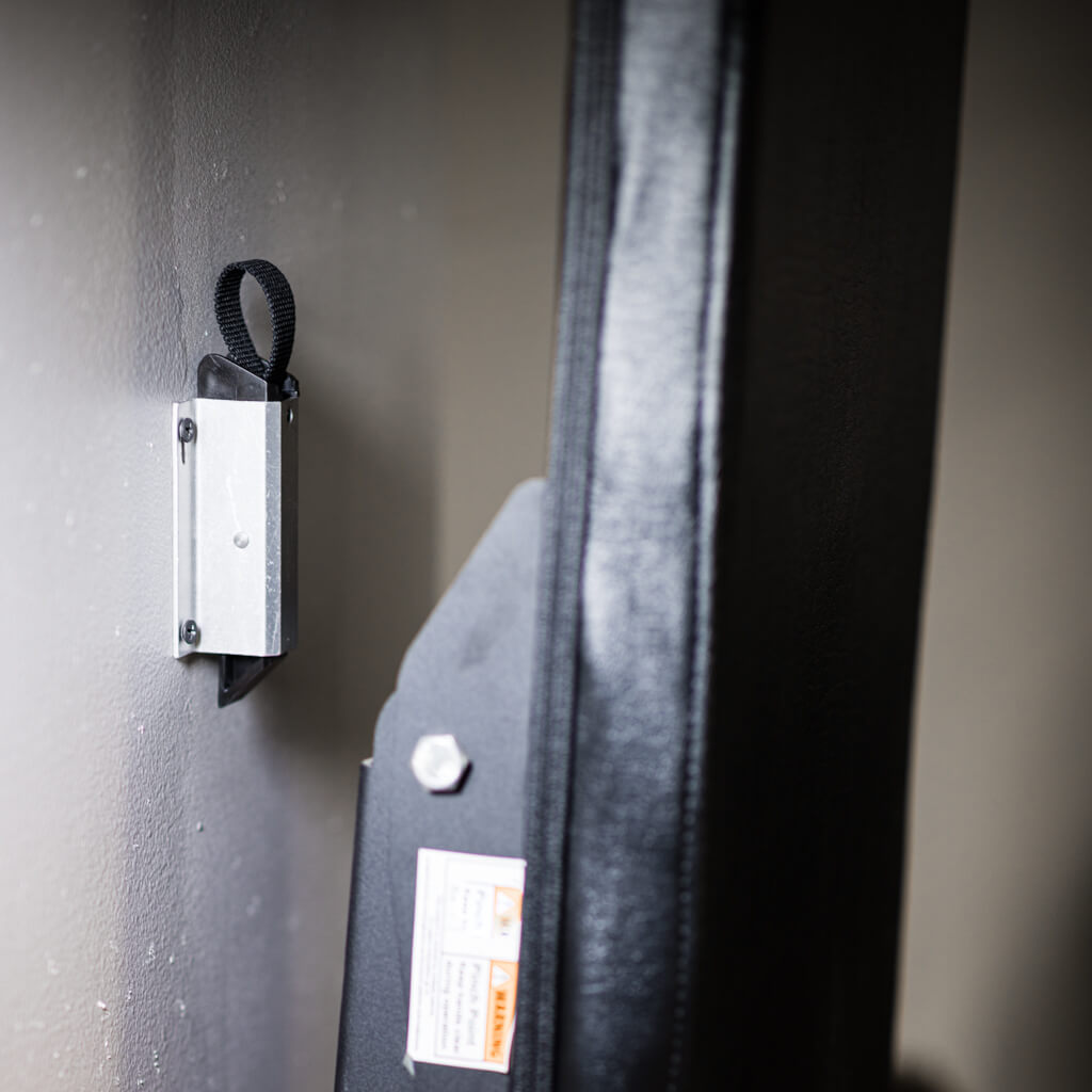 PRx Profile Bench Wall Locking System holding a folded bench against the wall