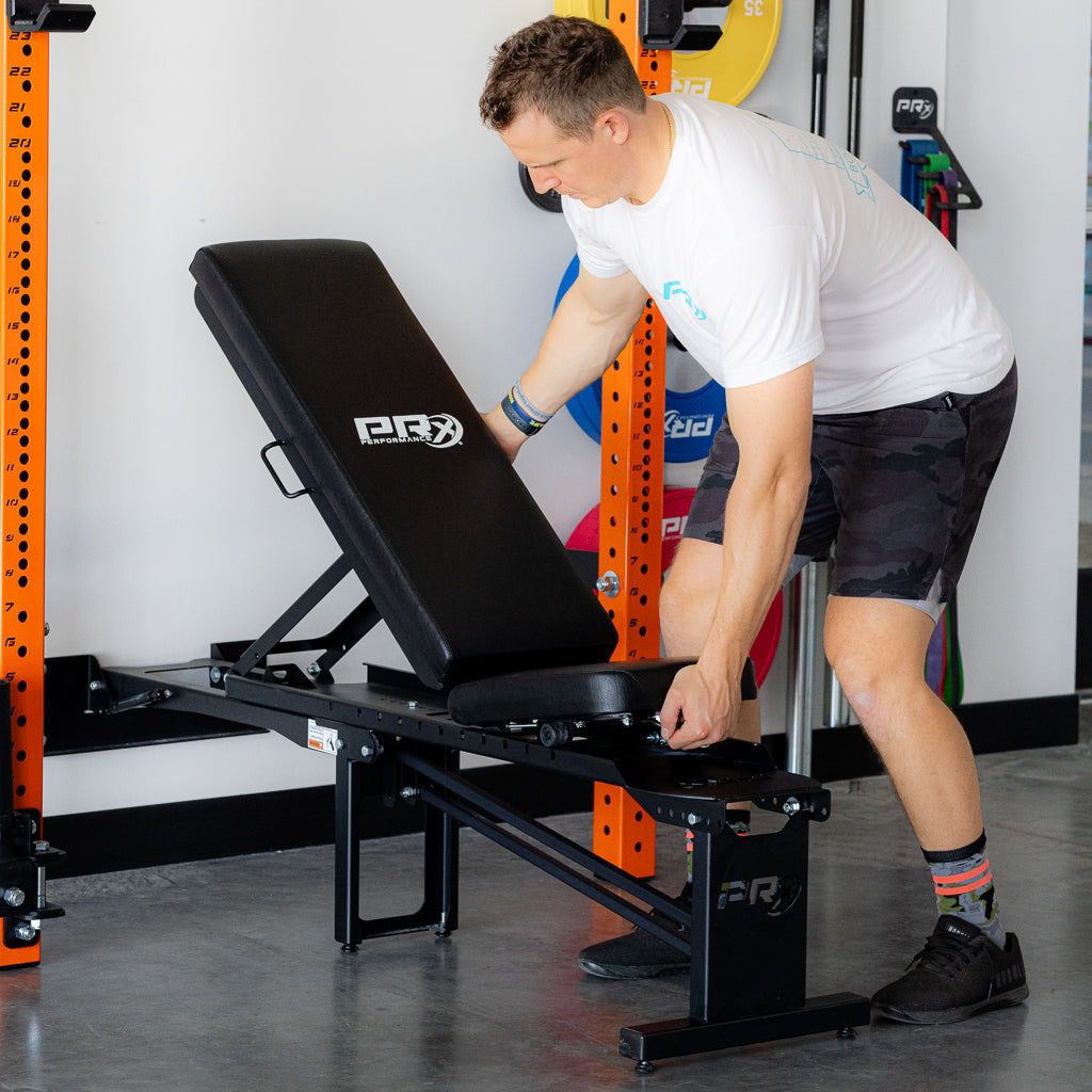 PRx Profile Incline Folding Bench in use inside a wall-mounted rack