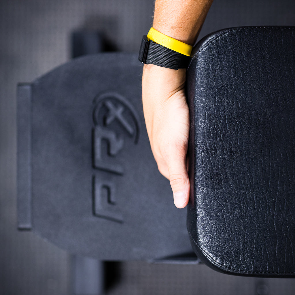 PRx Profile Incline Folding Bench stowed in a garage gym