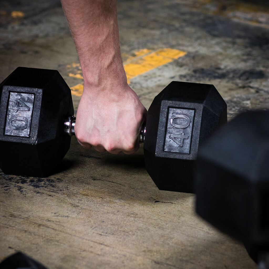 PRx rubber hex dumbbells stored on a dumbbell rack