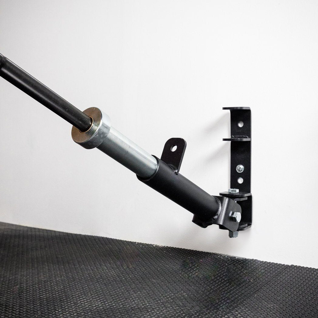 Barbell stored upright in the PRx Landmine / Bar Storage against a gym wall