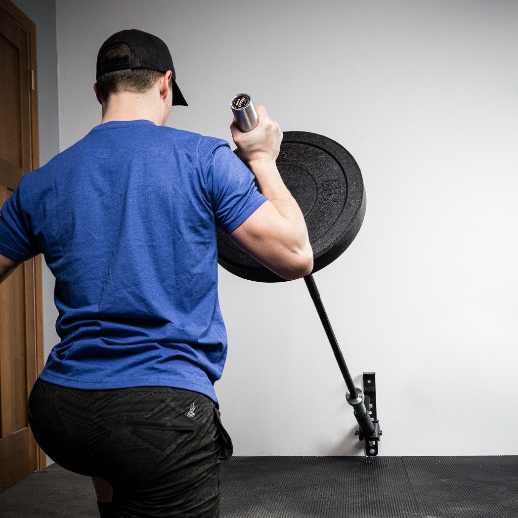 PRx wall-mounted landmine pivoting with a barbell during a rowing movement